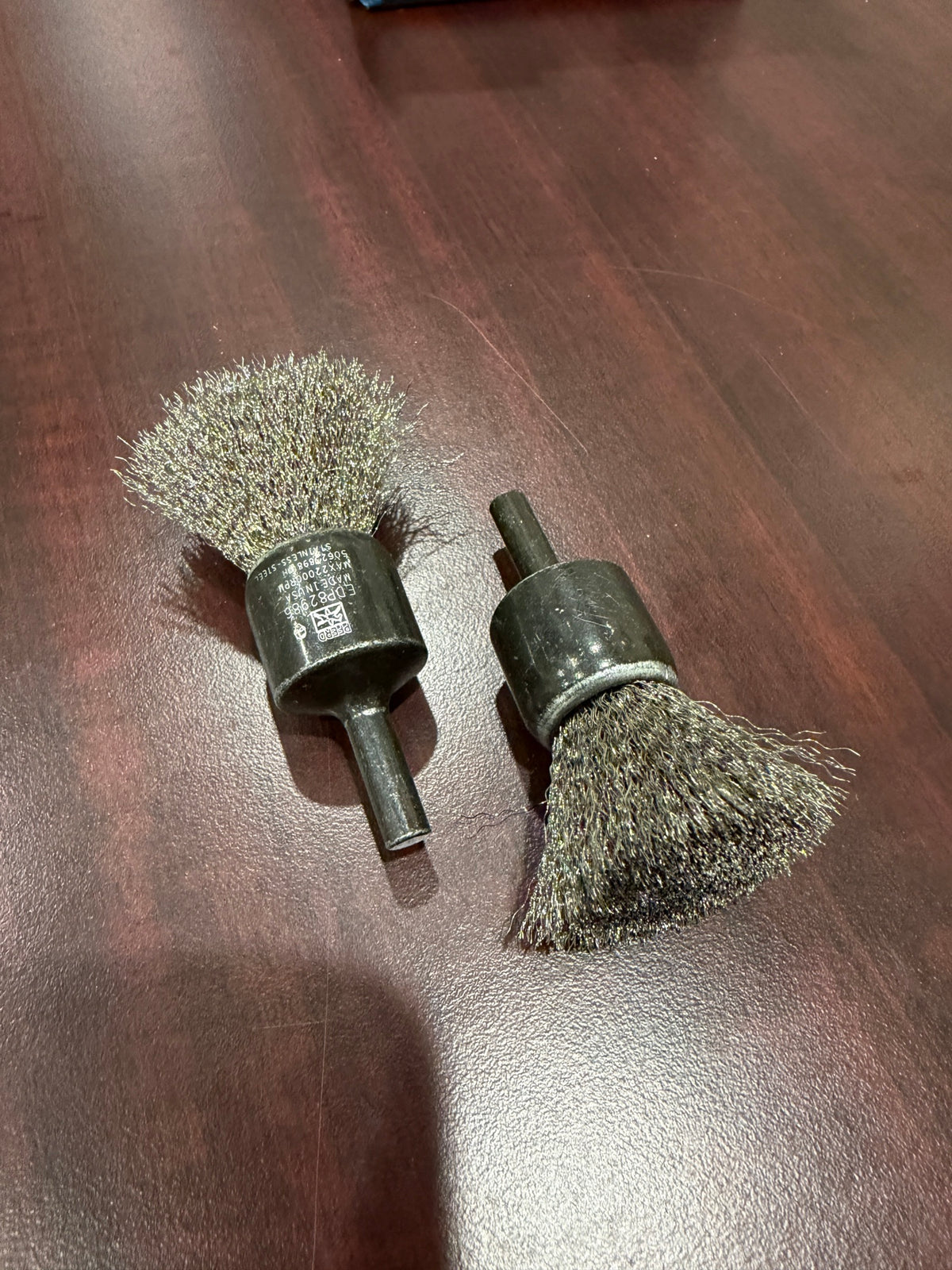 Two PFERD 82986 crimped stainless wire end brushes on a table